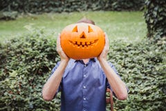 Mann im blauen Hemd, das großen Kürbis vor seinem Gesicht hält Glückliches Halloween lizenzfreie stockbilder Mann im blauen Hemd, das großen Kürbis vor seinem Gesicht hält Glückliches Halloween lizenzfreie stockbilder