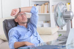 Mann leidet unter Hitze im Büro oder zu Hause Lizenzfreie Stockfotos Mann leidet unter Hitze im Büro oder zu Hause Lizenzfreie Stockfotos