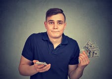 Mann mit dem intelligenten Telefon, das BargeldDollarscheine wegwirft stockfoto Mann mit dem intelligenten Telefon, das BargeldDollarscheine wegwirft stockfoto