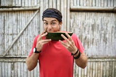 Mann mit Stoppel mit lustigem Gesichtsausdruck isst Wassermelone lizenzfreies stockbild Mann mit Stoppel mit lustigem Gesichtsausdruck isst Wassermelone lizenzfreies stockbild
