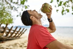Mann mit Stoppel trinkt von der Kokosnuss auf Sandstrand stockbilder Mann mit Stoppel trinkt von der Kokosnuss auf Sandstrand stockbilder