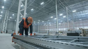 Mann trägt Metallbau im neuen modernen Industrielager stock footage Mann trägt Metallbau im neuen modernen Industrielager stock footage