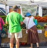 Mann- und Fraueneinkaufen für Gemüse bei Cherry Street Farmers Market lizenzfreie stockfotos Mann- und Fraueneinkaufen für Gemüse bei Cherry Street Farmers Market lizenzfreie stockfotos