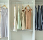 Mann und Frauenkleider, die an den Aufhängern in der Garderobe hängen Lizenzfreies Stockfoto Mann und Frauenkleider, die an den Aufhängern in der Garderobe hängen Lizenzfreies Stockfoto