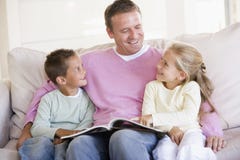 Mann und zwei Kinder, die im Wohnzimmer sitzen Lizenzfreie Stockfotos Mann und zwei Kinder, die im Wohnzimmer sitzen Lizenzfreie Stockfotos