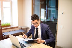 Mannelijk trots CEO holdingshandboek tijdens het werk aangaande draagbare netbook royalty-vrije stock afbeelding Mannelijk trots CEO holdingshandboek tijdens het werk aangaande draagbare netbook royalty-vrije stock afbeelding
