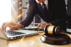 Mannelijke advocaat in het bureau met messingsschaal op houten lijst Rechtvaardigheid en wetsconcept in ochtendlicht royalty-vrije stock foto's Mannelijke advocaat in het bureau met messingsschaal op houten lijst Rechtvaardigheid en wetsconcept in ochtendlicht royalty-vrije stock foto's
