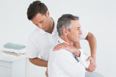Mannelijke chiropracticus die de rijpe mens onderzoeken stock foto's Mannelijke chiropracticus die de rijpe mens onderzoeken stock foto's