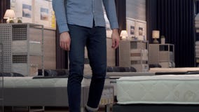 Mannelijke klant die orthopedisch matras en bed kiezen bij meubilairopslag stock videobeelden Mannelijke klant die orthopedisch matras en bed kiezen bij meubilairopslag stock videobeelden