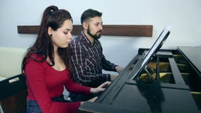 Mannelijke leraar met jonge studente het spelen piano in muzikale school stock footage Mannelijke leraar met jonge studente het spelen piano in muzikale school stock footage