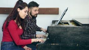 Mannelijke leraar met jonge studente het spelen piano in muzikale school stock footage Mannelijke leraar met jonge studente het spelen piano in muzikale school stock footage