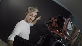 Mannelijke tiener influencer film zelf met een professionele camera in een studio voor zijn wekelijkse episode op videoblog - stock video Mannelijke tiener influencer film zelf met een professionele camera in een studio voor zijn wekelijkse episode op videoblog - stock video