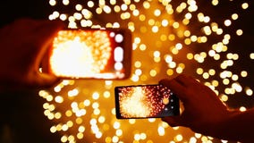 Mannen antecknar videopp fyrverkerier på den smarta telefonen stock video Mannen antecknar videopp fyrverkerier på den smarta telefonen stock video