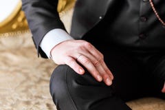 Mannen i dräkt satte hans hand på hans knä arkivbild Mannen i dräkt satte hans hand på hans knä arkivbild
