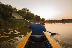 Mannflöße auf dem Kajak Kajakmannsonnenuntergang-Wassersport lizenzfreies stockfoto Mannflöße auf dem Kajak Kajakmannsonnenuntergang-Wassersport lizenzfreies stockfoto