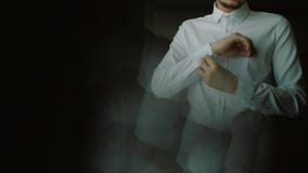 Mannknöpfe herauf seine weiße Hemdstellung in der Front eines hellen Fensters, des Geschäfts, der Mode und des Kleidungskonzeptes stock footage Mannknöpfe herauf seine weiße Hemdstellung in der Front eines hellen Fensters, des Geschäfts, der Mode und des Kleidungskonzeptes stock footage