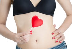 Mano de la mujer con los clavos rojos que sostienen la piruleta del corazón fotografía de archivo libre de regalías Mano de la mujer con los clavos rojos que sostienen la piruleta del corazón fotografía de archivo libre de regalías