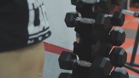 Mano de tomar de las mujeres jovenes pesas de gimnasia en el gimnasio metrajes Mano de tomar de las mujeres jovenes pesas de gimnasia en el gimnasio metrajes