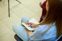 Mano de una muchacha con una pluma en una libreta blanca vacía fotografía de archivo Mano de una muchacha con una pluma en una libreta blanca vacía fotografía de archivo