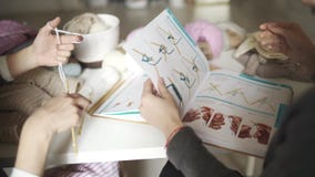 Mano del diseñador de moda que señala en el bosquejo de la ropa en libro metrajes Mano del diseñador de moda que señala en el bosquejo de la ropa en libro metrajes