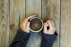 Mano della donna che tiene la tazza di caffè sulla tavola di legno fotografia stock libera da diritti Mano della donna che tiene la tazza di caffè sulla tavola di legno fotografia stock libera da diritti