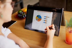 Mano della donna di affari che indica con lo stilo sul grafico sopra lo schermo convertibile del computer portatile nel modo dell fotografia stock Mano della donna di affari che indica con lo stilo sul grafico sopra lo schermo convertibile del computer portatile nel modo dell fotografia stock