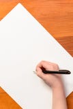 Mano di un ragazzino con una penna nera su un fondo bianco immagini stock libere da diritti Mano di un ragazzino con una penna nera su un fondo bianco immagini stock libere da diritti