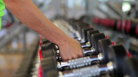 Mano que lleva a cabo pesa de gimnasia Cierre para arriba Brazo muscular en metrajes Mano que lleva a cabo pesa de gimnasia Cierre para arriba Brazo muscular en metrajes