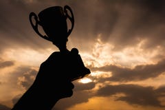 Mano que sostiene el trofeo del ganador imagen de archivo Mano que sostiene el trofeo del ganador imagen de archivo