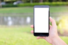 Mano usando el teléfono móvil en el parque imagen de archivo Mano usando el teléfono móvil en el parque imagen de archivo