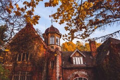 Manor house with trees in autumn colors and fall trees. Old Victorian Haunted House with ghosts. Abandoned house in autumn wood