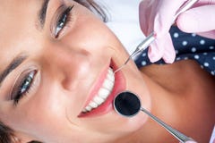 Manos del dentista que trabajan en los dientes femeninos Foto de archivo Manos del dentista que trabajan en los dientes femeninos Foto de archivo