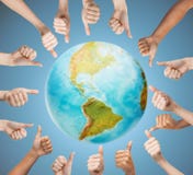 Manos humanas que muestran los pulgares para arriba en círculo sobre la tierra imagenes de archivo Manos humanas que muestran los pulgares para arriba en círculo sobre la tierra imagenes de archivo
