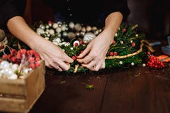 Young Cute smiling Woman designer preparing Christmas Evergreen Tree Wreath. Manufacturer of Christmas decor with their stock images Young Cute smiling Woman designer preparing Christmas Evergreen Tree Wreath. Manufacturer of Christmas decor with their stock images