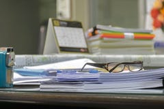 Many documents are placed on the desk.Pen and goggles are placed stock image Many documents are placed on the desk.Pen and goggles are placed stock image
