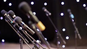 Many microphones on stage in the rays of twinkling lights stock video Many microphones on stage in the rays of twinkling lights stock video