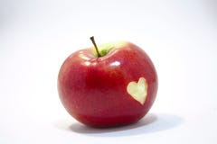 Manzana roja en un fondo blanco, con un corazón cortado en su lado imagen de archivo Manzana roja en un fondo blanco, con un corazón cortado en su lado imagen de archivo