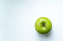 Manzana verde en un lugar blanco del fondo para una inscripción fotografía de archivo libre de regalías Manzana verde en un lugar blanco del fondo para una inscripción fotografía de archivo libre de regalías