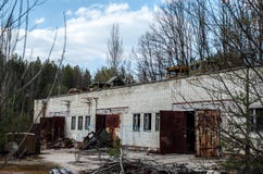 Maquinaria quebrada e abandonada na zona de exclusão de Chernobyl Construção industrial com os carros quebrados no telhado imagem de stock Maquinaria quebrada e abandonada na zona de exclusão de Chernobyl Construção industrial com os carros quebrados no telhado imagem de stock