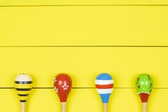 Maracas coloridos no fundo amarelo das placas de madeira imagem de stock Maracas coloridos no fundo amarelo das placas de madeira imagem de stock