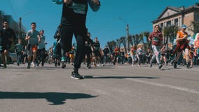Maratona da cidade Multidão de corredores dos povos e dos atletas corridos ao longo da estrada na cidade filme Maratona da cidade Multidão de corredores dos povos e dos atletas corridos ao longo da estrada na cidade filme