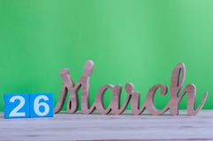 March 26th. Day 26 of month, daily wooden calendar on table and green background. Spring time, empty space for text stock photography March 26th. Day 26 of month, daily wooden calendar on table and green background. Spring time, empty space for text stock photography