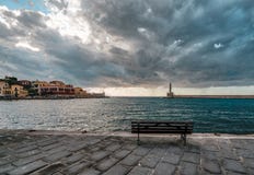 Margem e farol venetian do porto do panorama no porto velho de Chania no por do sol, Creta, Grécia fotografia de stock Margem e farol venetian do porto do panorama no porto velho de Chania no por do sol, Creta, Grécia fotografia de stock