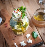 Marinated сыр фета в оливковом масле, травах и хлопьях красного перца на деревянной предпосылке стоковое изображение rf Marinated сыр фета в оливковом масле, травах и хлопьях красного перца на деревянной предпосылке стоковое изображение rf