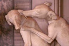 Marmorera skulptur var två hundkapplöpning kysser på bakgrunden av en marmorvägg arkivfoto Marmorera skulptur var två hundkapplöpning kysser på bakgrunden av en marmorvägg arkivfoto