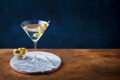 Martini cocktail with green olives on marble cutting board. Copy space. Royalty Free Stock Photography Martini cocktail with green olives on marble cutting board. Copy space. Royalty Free Stock Photography