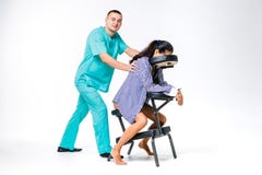 Masaje y oficina del tema Terapeuta de sexo masculino con el traje azul que hace detrás y el masaje del cuello para el trabajador foto de archivo libre de regalías Masaje y oficina del tema Terapeuta de sexo masculino con el traje azul que hace detrás y el masaje del cuello para el trabajador foto de archivo libre de regalías