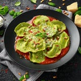 Massa italiana do ravioli enchida com pesto da manjericão, a ricota cremosa e os pinhões crocantes Alimento saud?vel do vegetaria imagem de stock Massa italiana do ravioli enchida com pesto da manjericão, a ricota cremosa e os pinhões crocantes Alimento saud?vel do vegetaria imagem de stock