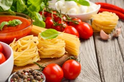 Massa, vegetais, ervas e especiarias para o alimento italiano na tabela de madeira rústica imagem de stock Massa, vegetais, ervas e especiarias para o alimento italiano na tabela de madeira rústica imagem de stock