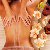 Massör som gör massage på kvinnabaksida i brunnsortsalong royaltyfria bilder Massör som gör massage på kvinnabaksida i brunnsortsalong royaltyfria bilder